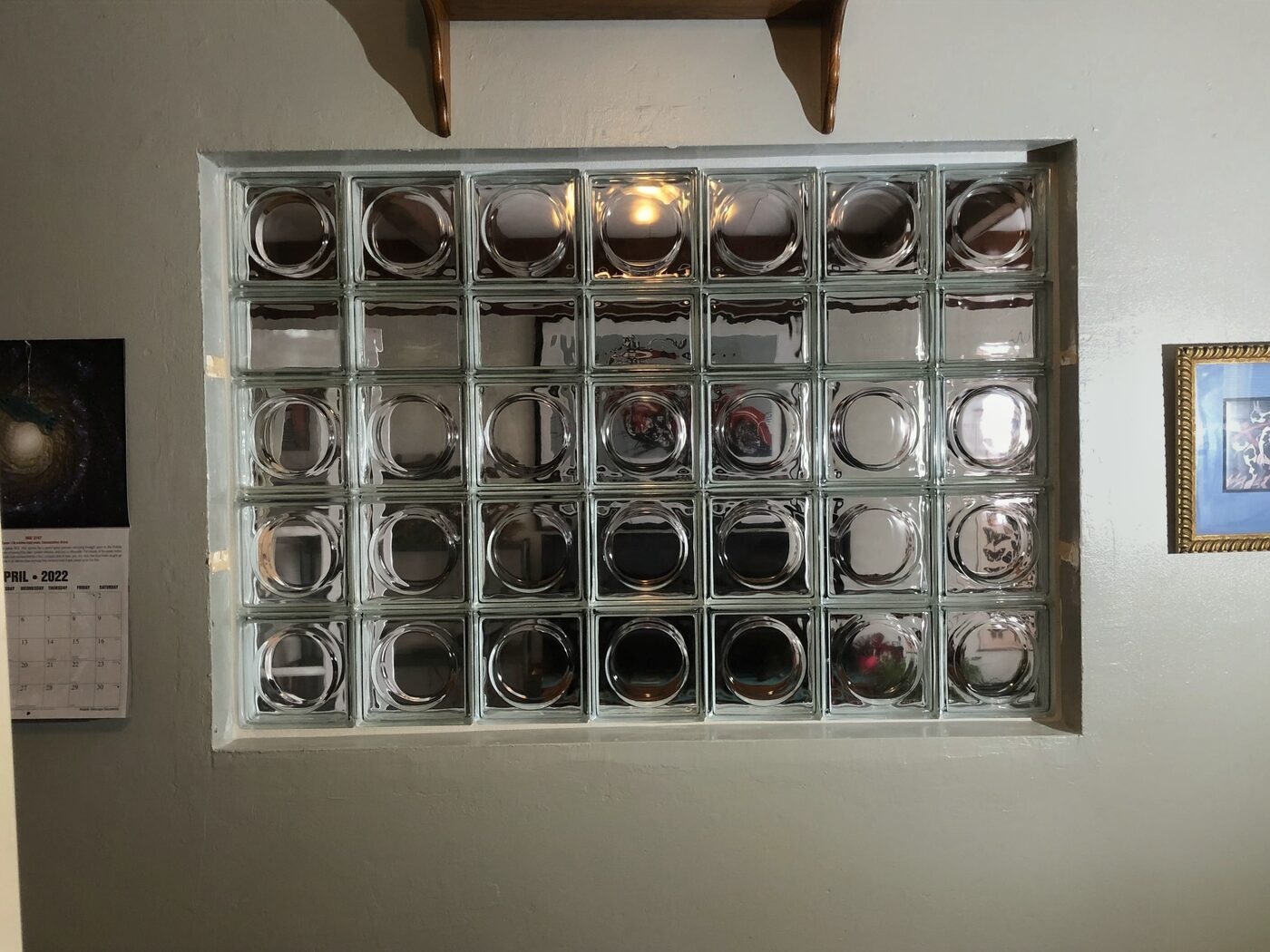 Close-up of a decorative glass block window with round lens-style blocks set into an interior wall