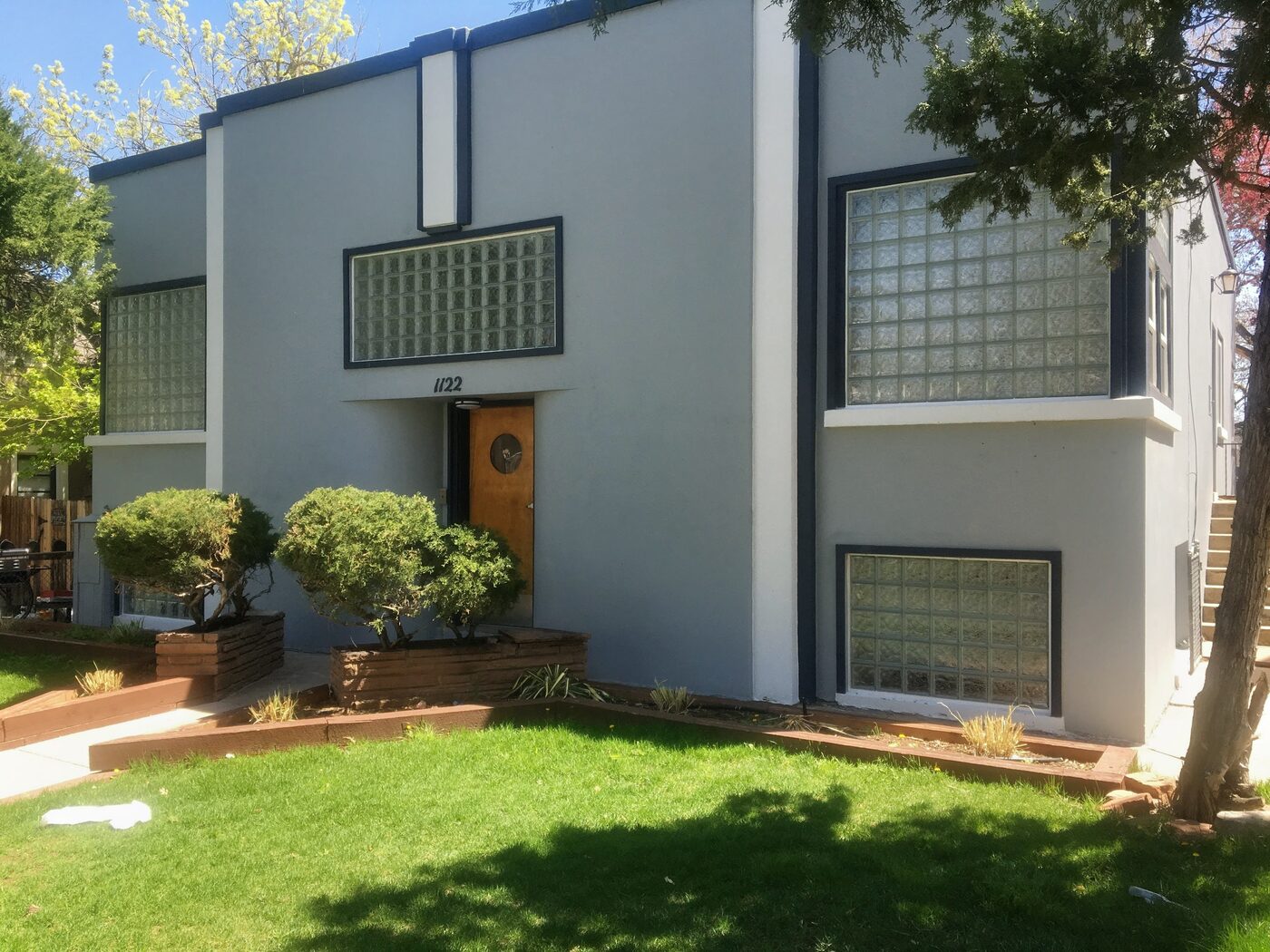 Art-deco style home with several glass block windows in the stucco façade