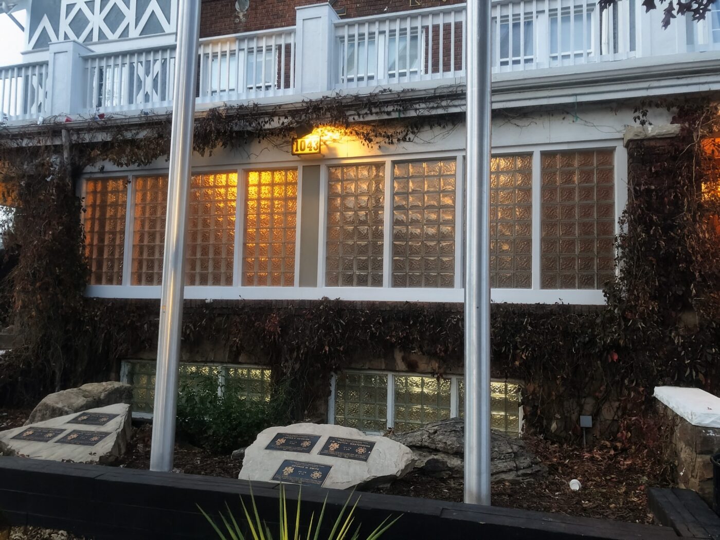 Historic building front lit from within through rows of glass block windows at dusk